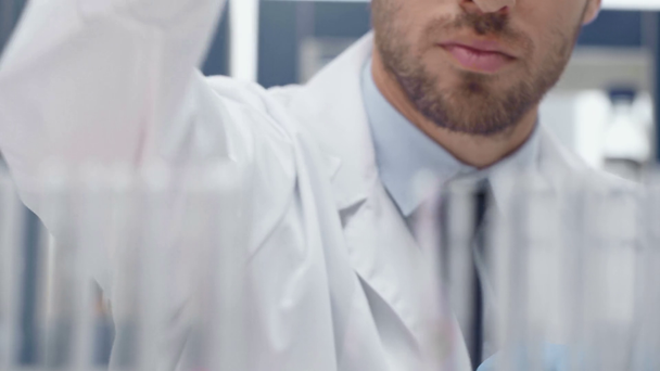 vista cortada do cientista masculino usando placa de Petri e pipeta durante o exame de sangue em laboratório
 - Filmagem, Vídeo