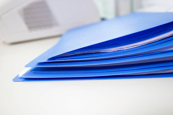 Folder plików niebieski i papieru na biały stół w biurze, artykuły biurowe koncepcja kopia miejsce. - Zdjęcie, obraz