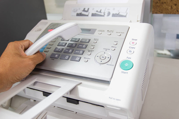L'homme de main utilise un fax dans le bureau. Concept d'entreprise
  - Photo, image