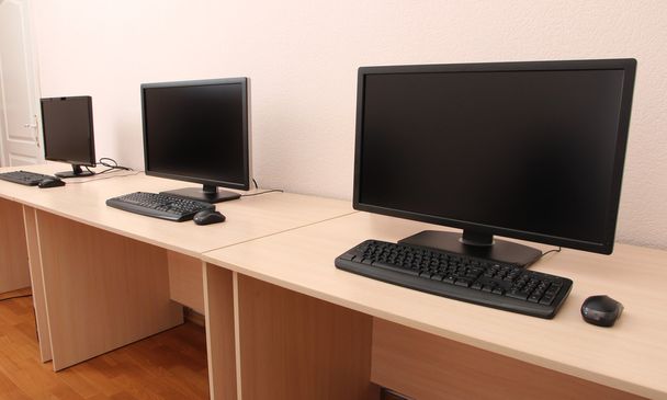 υπολογιστές στα τραπέζια στο δωμάτιο - Φωτογραφία, εικόνα