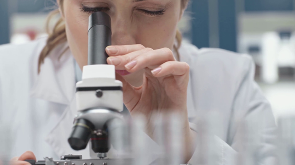 Beyaz önlük laboratuvar mikroskop aramak içinde kadın bilim adamının seçici odak - Video, Çekim