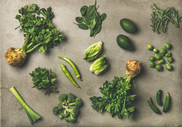 Zdravá Veganská salát ingredience rozložení. Ploché lay ze zelené zeleniny a bylin šedé betonové tabulka pozadí, pohled shora. Vegetariánská, čisté jídlo, zdravé vaření, syrové, jarní lehké jídlo koncept - Fotografie, Obrázek