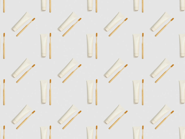 bamboo toothbrushes and toothpaste in different directions on grey background, seamless background pattern - Photo, Image