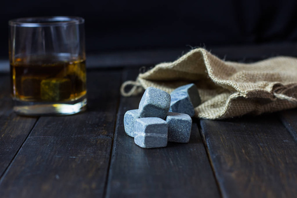 Whiskey in a glass with stones for cooling drinks on a wooden table - Foto, immagini
