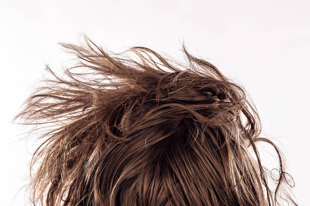 Closeup of a morning bed head with a natural messy hair from behind of young man in his 20s, isolated on white - Concept of hangover, insomnia, sleeplessness, confident appearance or casual hipster hairstyle. - Photo, Image