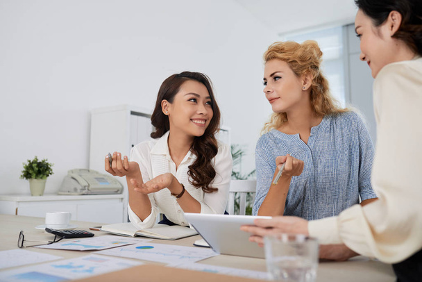 Женщины-менеджеры смешанных рас обсуждают работу на ежедневной встрече
 - Фото, изображение