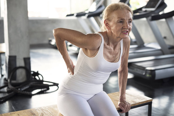 Seniorin leidet an Rückenschmerzen Ursache für Fitness. - Foto, Bild