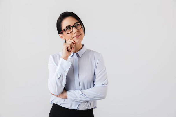 Image of attractive secretary woman wearing eyeglasses standing in the office isolated over white background - Foto, Imagem