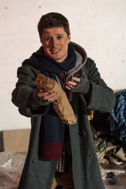 hajléktalan ember tartja kenyér baguette, feszített kezét - Fotó, kép