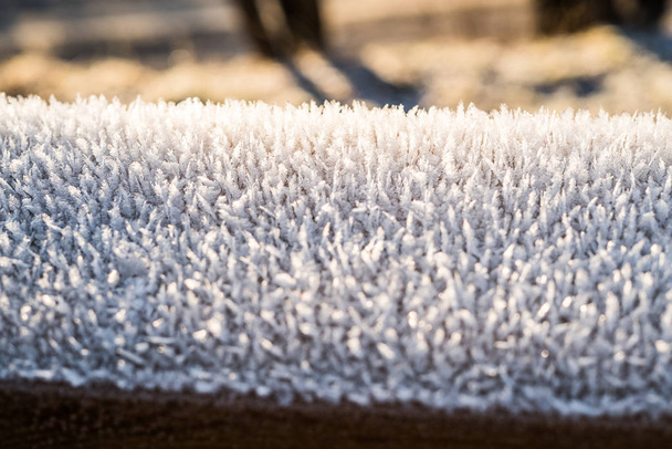 Detalle de primer plano de escarcha fría cristalizada blanca que cubre una barandilla congelada fuera de una mañana de invierno fresca, con espacio de copia - Concepto de temperatura helada estacional y clima de congelación
. - Foto, imagen