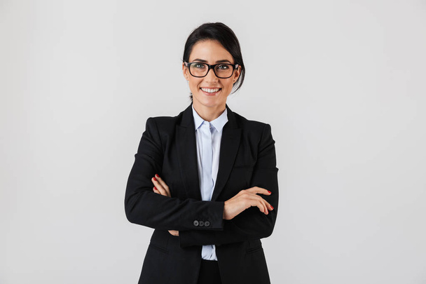 Portrait of successful businesswoman 30s in formal wear and eyeglasses standing in the office isolated over white background - Фото, зображення