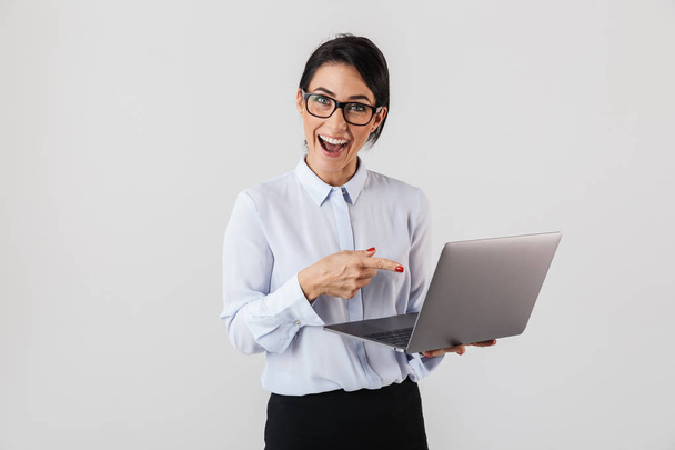 Retrato de empresária bem sucedida vestindo óculos segurando laptop prata no escritório isolado sobre fundo branco
 - Foto, Imagem