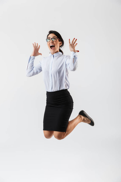 Full length portrait of a pretty businesswoman jumping isolated over white background, celebrating success - Fotoğraf, Görsel