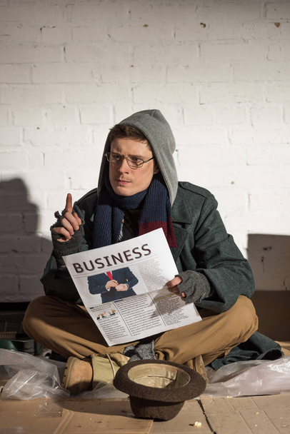 dakloze man business krant lezen en tonen idee teken - Foto, afbeelding