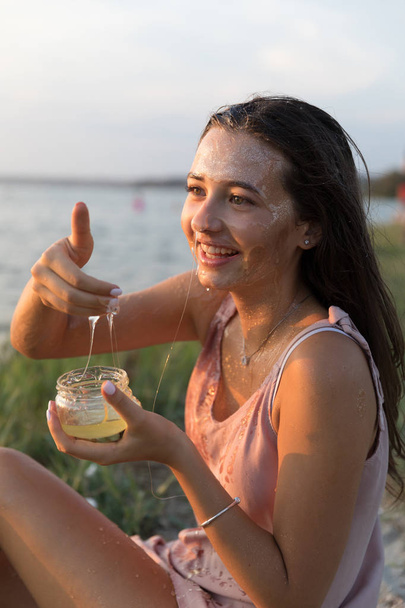 Young beautiful woman with honey on her face. Healthy perfect skin. Honey treatment. - Fotografie, Obrázek