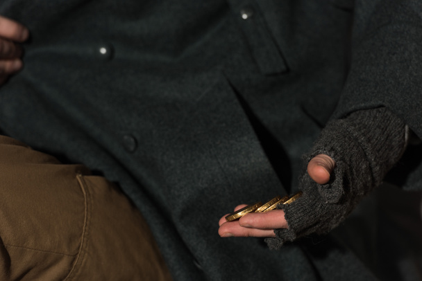 μερική άποψη του ανθρώπου άστεγοι ζητιάνος να πάρει νομίσματα από την τσέπη  - Φωτογραφία, εικόνα
