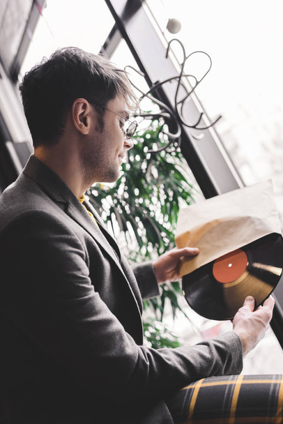 young man in sunglasses holding vinyl record in hands - Foto, imagen