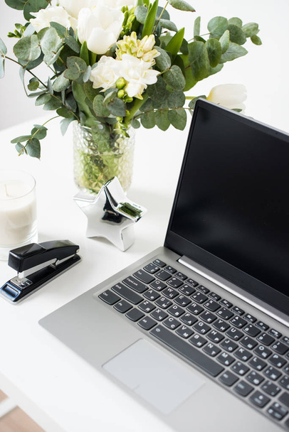 Hipster bloggers χώρο εργασίας, φορητό υπολογιστή και τα λουλούδια λευκά επιτραπέζια - Φωτογραφία, εικόνα