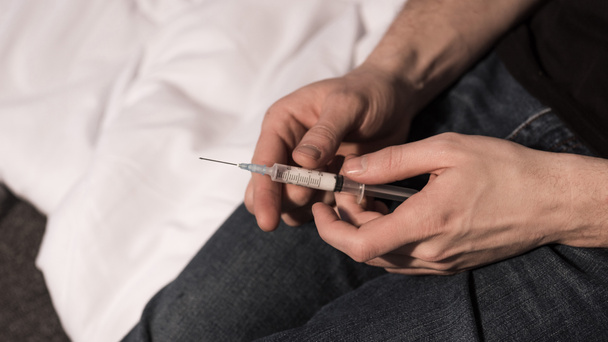 concentrazione selettiva di narcomaniaco uomo siringa con dose di eroina
 - Foto, immagini