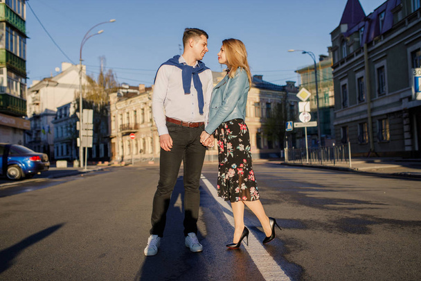 young stylish couple posing on sun lighted street - Fotó, kép