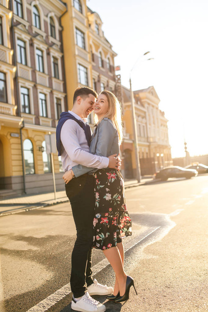 young stylish couple posing on sun lighted street - Φωτογραφία, εικόνα