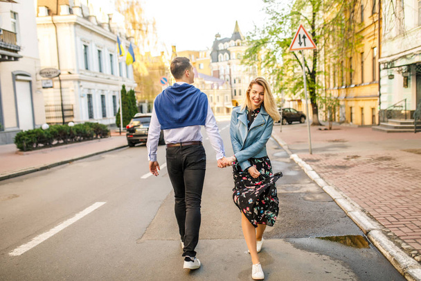 pareja joven y elegante caminando por la calle tomados de la mano
 - Foto, imagen