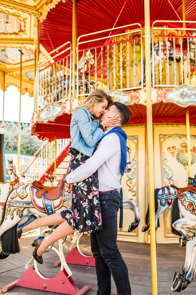happy couple, young man holding his girlfriend at carousel - Photo, image