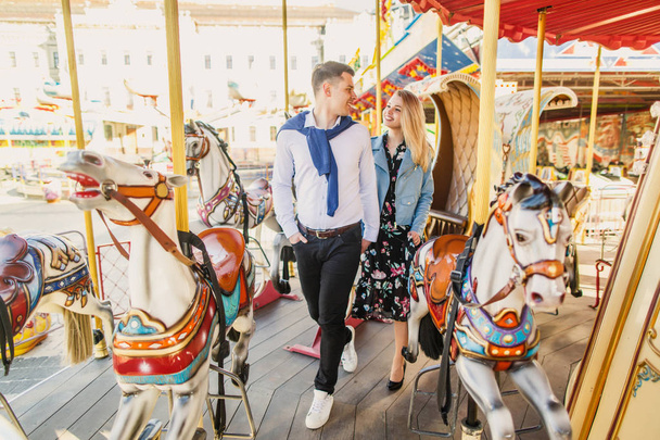 smiling young couple walking on carousel - Foto, afbeelding