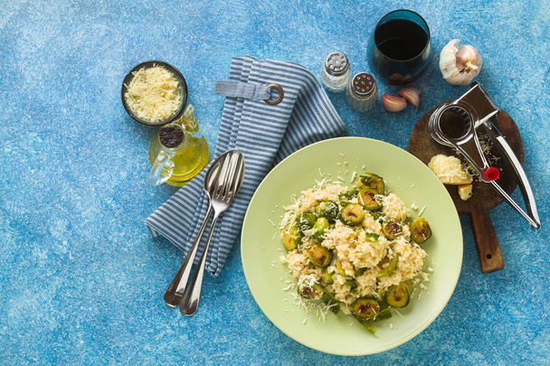 Italian spring risotto with Brussels sprouts and parmesan cheese on the table. healthy food for the whole family, party or restaurant menu and red wine - Photo, Image