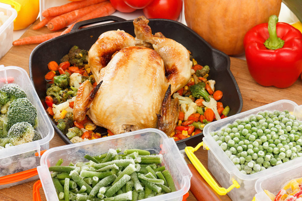 Fresh frozen vegetables mixed in plastic containers, fried chicken in pan. Healthy freezer food and meals. - Foto, imagen