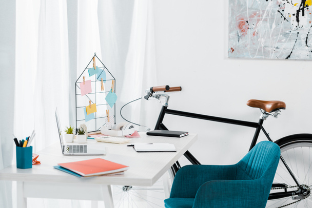 Acogedora oficina en casa con muebles modernos y bicicleta negra
 - Foto, imagen
