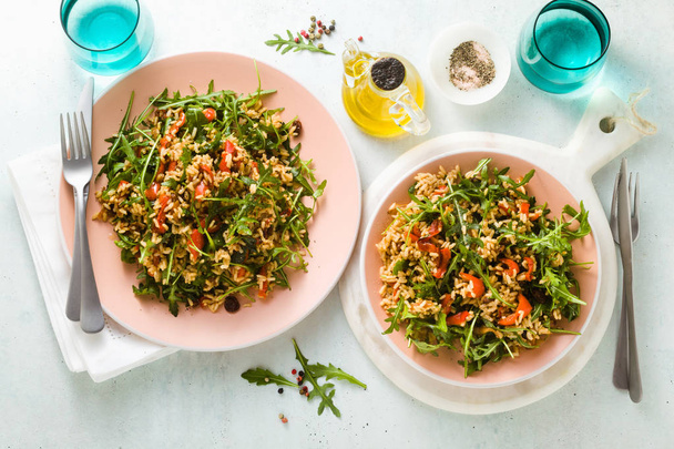 rice salad with baked bell peppers, arugula, olives and capers. Healthy vegan spring recipe for the whole family or party - Photo, Image