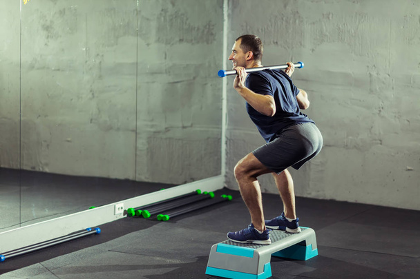 hombre guapo haciendo ejercicio con pesas en el gimnasio - Foto, Imagen