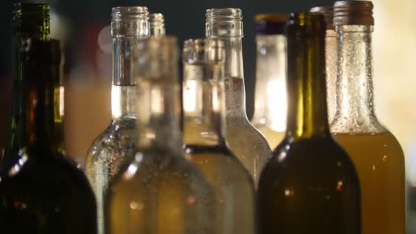 Primo piano di bottiglie piene di alcol di diversi colori al bar con illuminazione interna soffusa
 - Filmati, video