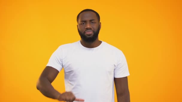 Disappointed afro american guy showing thumbs down isolated on yellow background - Video