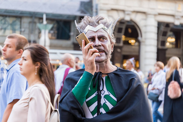 Moscow, Tverskaya street, September 8, 2018: A man in a carnival costume and with a tragic make-up holding a smartphone - Foto, Imagen