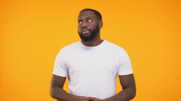 Disappointed afro american male doing facepalm gesture against yellow background - Footage, Video