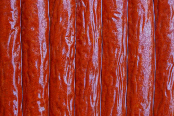textura natural roja de una variedad de salchichas en envases de plástico
 - Foto, Imagen