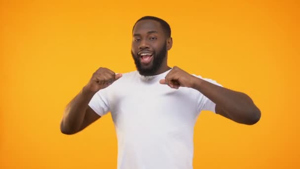 Happy african american man dancing and singing, isolated on yellow background - Metraje, vídeo