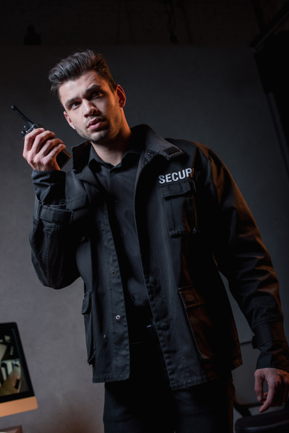 handsome guard in uniform using walkie-talkie at workplace  - Fotografie, Obrázek
