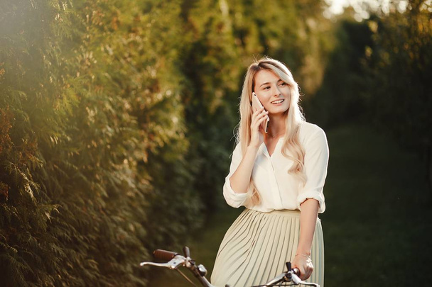 portrait of pretty sexy girl  posing with vintage  retro bicycle using smartphone. - Foto, immagini