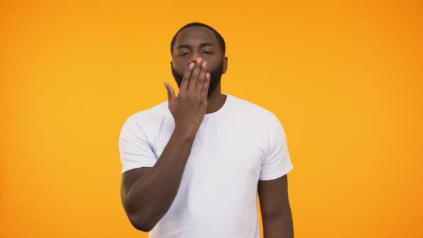 Guapo afroamericano chico enviando aire beso en cámara, aislado en amarillo
 - Imágenes, Vídeo