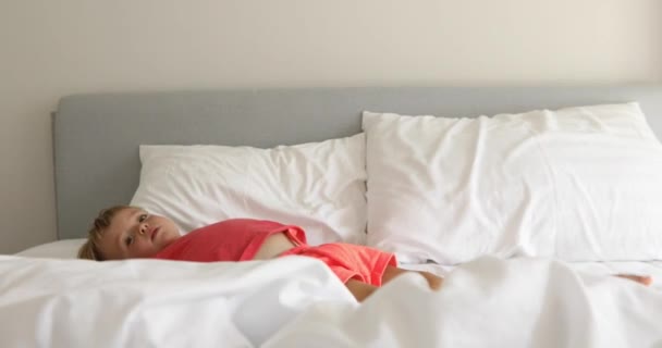 Niemowlę dziecko na białe łóżko - Materiał filmowy, wideo