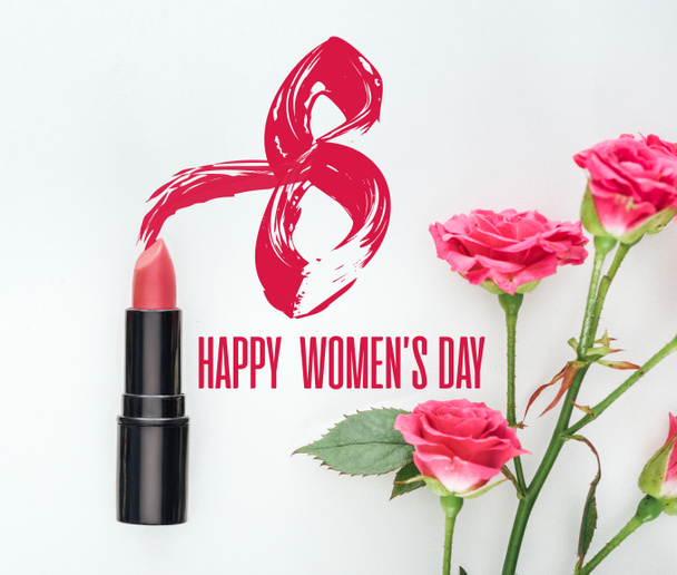 vista superior de lápiz labial y rosas rosadas sobre fondo blanco con letras feliz día de las mujeres
  - Foto, Imagen