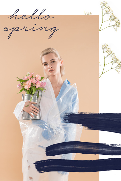 menina atraente segurando regador pode com flores e de pé em eco roupas no fundo bege com Olá primavera ilustração
  - Foto, Imagem