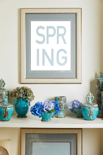 picture frame with spring lettering and turquoise ceramic ornate vintage vases with flowers on shelf - Photo, Image