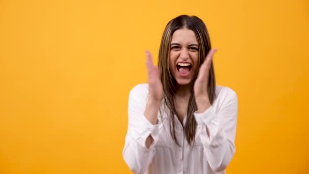 Happy excited woman clapping on yellow background - Video