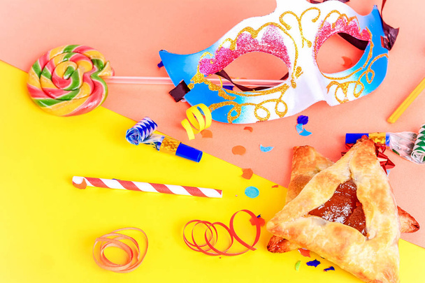 Top view of Purim background with carnival mask, party costume and hamantaschen cookies. Purim celebration concept - Фото, изображение