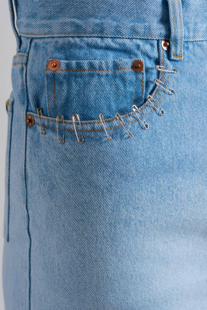 Blue jeans fifth pocket closeup with many small pins. Superstition. - Photo, Image