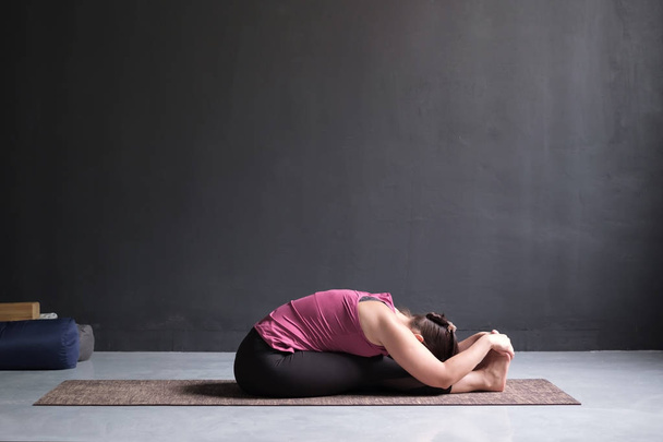 Frau praktiziert Yoga, sitzt nach vorne gebeugt Pose - Foto, Bild